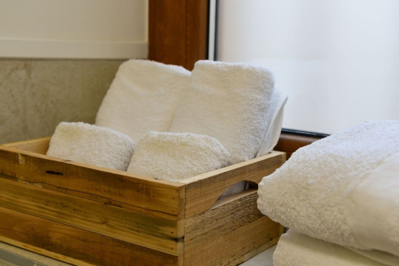 Una caja de madera con varias toallas blancas.