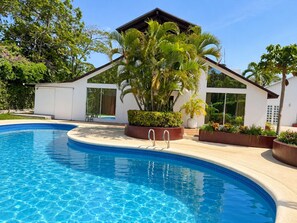 A swimming pool with a modern house in the background.