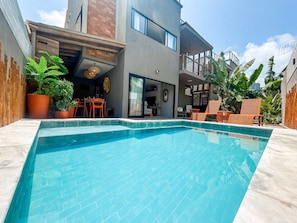 A modern house with a swimming pool, outdoor seating, and potted plants. - Casa Linda quase que pe na Areia (Sao Miguel dos Milagres)