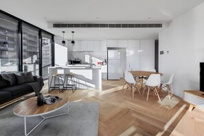A modern apartment with a living area, kitchen, and dining space. - Lakeside Lookout Modern Living with Majestic Views (Melbourne)