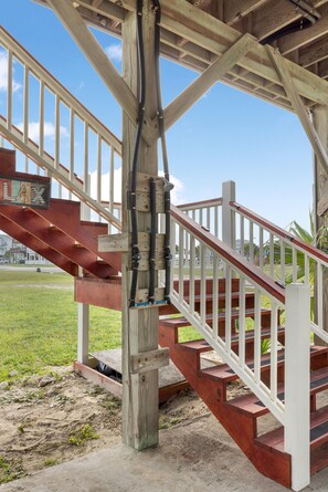 A wooden staircase with a white railing leading to a covered area. - Stylish Galveston Island Getaway Near the Beach (Galveston)