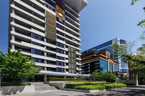 A multi-story hotel with a modern design, featuring balconies and a central atrium. - Refresh at Rhapsody City Fringe Contemporary (Melbourne)