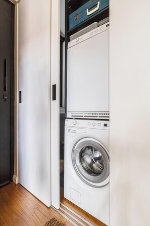 A laundry room with a front-loading washing machine and a dryer. - Hikari Haven Richmonds Creative Spirit near Cafs (Richmond)