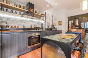 A modern kitchen with a central island, built-in oven, and stainless steel appliances. - Hikari Haven Richmonds Creative Spirit near Cafs (Richmond)