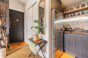 A modern kitchen with a stainless steel refrigerator, wooden cabinets, and a countertop with kitchen utensils. - Hikari Haven Richmonds Creative Spirit near Cafs (Richmond)