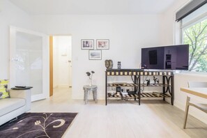 Un saló modern amb un sofà, una taula de centre, una televisió i una consola decorada amb objectes decoratius.