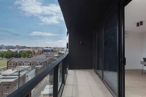 A balcony with a city view, a glass door, and a tiled floor. - South Yarra Serenity on Chapel St with City Views (South Yarra)