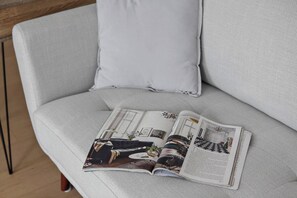 A magazine on a grey sofa with a cushion. - South Yarra Serenity on Chapel St with City Views (South Yarra)