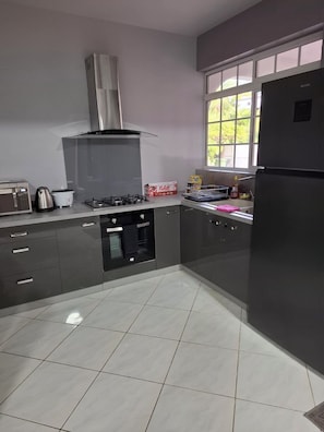 A modern kitchen with a gas stove, microwave, and stainless steel appliances.