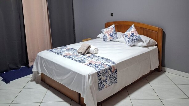 A hotel room with a bed, curtains, and a tiled floor. - KEYKI HOME (PIRAE)