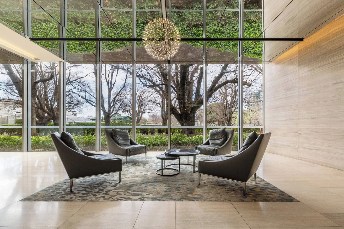 A modern interior with large windows, a central table, and two sofas.