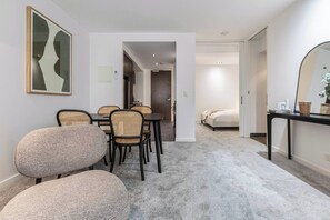 A modern interior with a dining area, a bed, and a mirror. - Mordyn at Victoria Brewery Parkside Escape w Pool (East Melbourne)