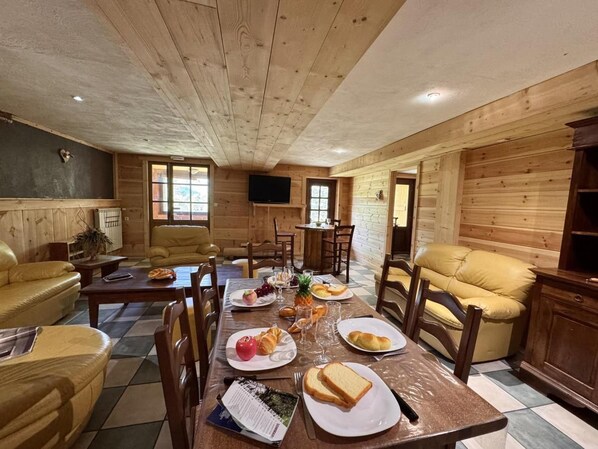 Ein Essbereich mit einem Holztisch, gedeckt für eine Mahlzeit, umgeben von Holzstühlen.