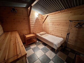 A small wooden room with a bed, a table, and a chair. - 300 meters from the ski slopes, patio, 120 m², Vars (Vars)