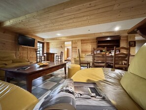 A cozy log cabin interior with a dining area, a sofa, and a television. - 300 meters from the ski slopes, patio, 120 m², Vars (Vars)