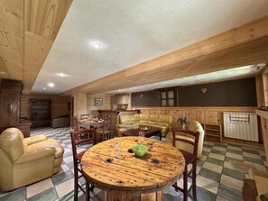 A wooden interior with a round table, leather chairs, and a checkered floor. - 300 meters from the ski slopes, patio, 120 m², Vars (Vars)