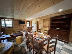 A wooden interior with a dining table set for four, surrounded by chairs. - 300 meters from the ski slopes, patio, 120 m², Vars (Vars)