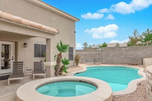 A backyard with a swimming pool, lounge chairs, and a small hot tub. - Luxury Vegas Escape 4BR, Pool/Spa, Game Room & BBQ (Las Vegas)