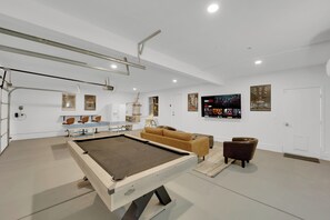 A modern living room with a pool table, comfortable seating, and artwork on the walls. - Luxury Vegas Escape 4BR, Pool/Spa, Game Room & BBQ (Las Vegas)