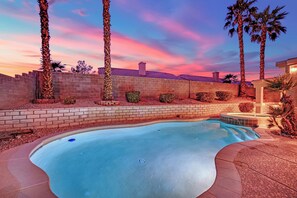 A swimming pool with a brick border, palm trees, and a sunset sky. - Luxury Vegas Escape 4BR, Pool/Spa, Game Room & BBQ (Las Vegas)