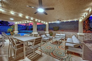 An outdoor patio with a pool, seating area, and ceiling fan. - Luxury Vegas Escape 4BR, Pool/Spa, Game Room & BBQ (Las Vegas)