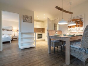 Ein modernes Interieur mit Essbereich, Küche und Schlafzimmer.