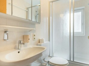 A bathroom with a sink, toilet, and a glass shower enclosure. - 4 in the House at Blanker-hans-weg 5 (St. Peter-Ording)
