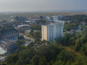 A multi-story building with a flat roof and a parking lot in front. - Holiday Apartment 19 (St. Peter-Ording)