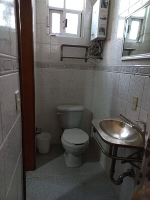 A small bathroom with a toilet, a sink, and a window above the toilet. - Furnished Loft in Colonia Juárez, Alcaldía Cuauhté CDMX (Cuauhtémoc,)