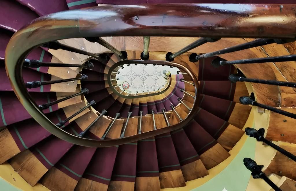 Una escalera de caracol con un elemento decorativo central.
