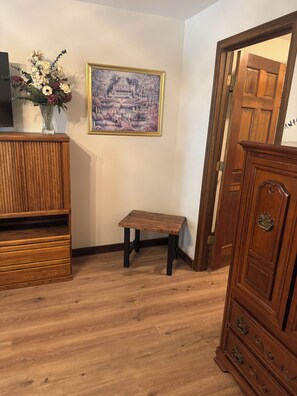A room with a wooden cabinet, a small table, and a framed picture on the wall. - 3-bedroom house in serene Pacific with beautiful views on a wraparound deck (Pacific)