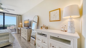 A hotel room with a bed, a TV, a dresser, a mirror, and a window with a view. - Siesta Key Penthouse with Expansive Ocean Views (Siesta Key)