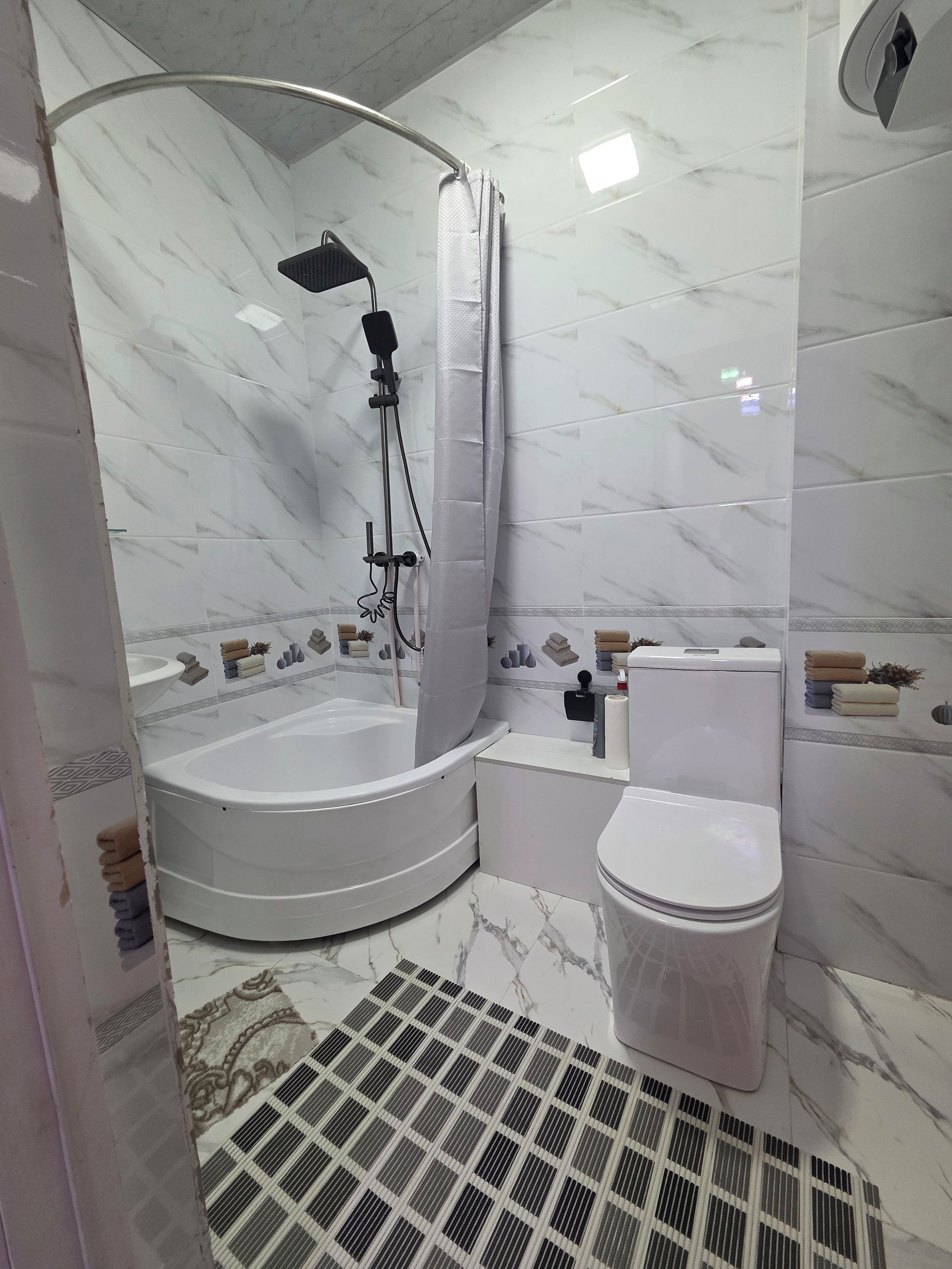 Ein Badezimmer mit einer Eckbadewanne, einer Toilette und einer Duschkabine.