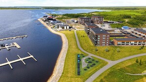 An aerial view of a waterfront property with a dock, buildings, and green spaces. - Stunning beachfront apartment for 1-8 people in Oulu Pateniemenranta. (Oulu)