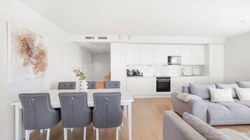 A modern kitchen with white cabinets and a built-in oven.