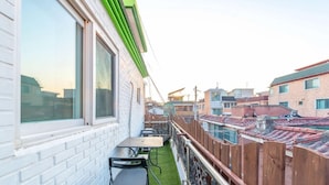 A residential building with a balcony, a table, and chairs. - Seeu House (Seoul)