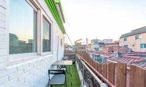 A residential building with a balcony, a table, and chairs. - Seeu House (Seoul)