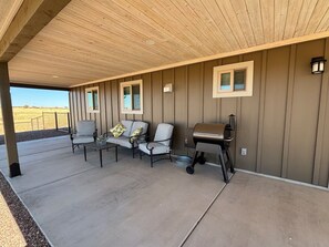 A covered patio with a barbecue grill, seating area, and a view of the outdoors. - Ben's Place - A Quiet Sanctuary where you can enjoy sunrises and sunsets. (Sonoita)