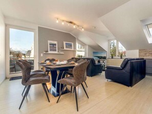 Ein modernes Loft-Apartment mit Essbereich, Sitzgelegenheiten und Blick ins Freie.