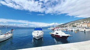 A marina with boats docked, calm water, and a town in the background. - Old Square Senj apartment: the authentic atmosphere of the old coastal town. (Senj)