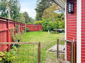 A fenced backyard with a wooden deck, a table, and chairs. - 5 Person Holiday Home in Solvesborg (Sölvesborg)