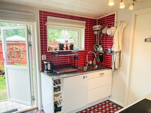 A compact kitchen with a window, a sink, and a built-in storage unit. - 5 Person Holiday Home in Solvesborg (Sölvesborg)