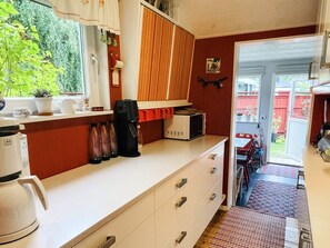 Una cocina compacta con cafetera, tostadora y armarios.