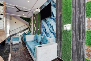A modern interior with a staircase, seating area, and a wall with a marble-like pattern.