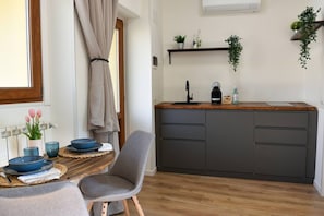 Una cucina moderna con piano di lavoro in legno, mobili grigi e una finestra con tende.