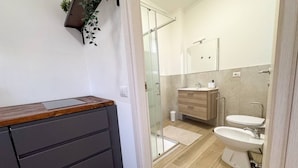 A modern bathroom with a shower, toilet, and bidet. - Fly&Rest MXP | Unit 2 | 24/7 Airport Transfer (Casorate Sempione)