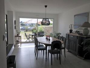 A modern kitchen with a dining area, large windows, and a view of the outside. - Michelle's House (Pont-l'Abbé)