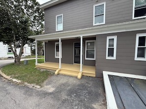 A two-story house with a covered porch and a front door. - Dog-Friendly 3BR Townhome · Parking & Workspace (Southbridge)