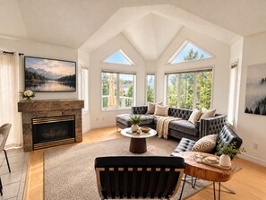 Un salón amplio con chimenea, ventanas grandes y una zona de estar acogedora.