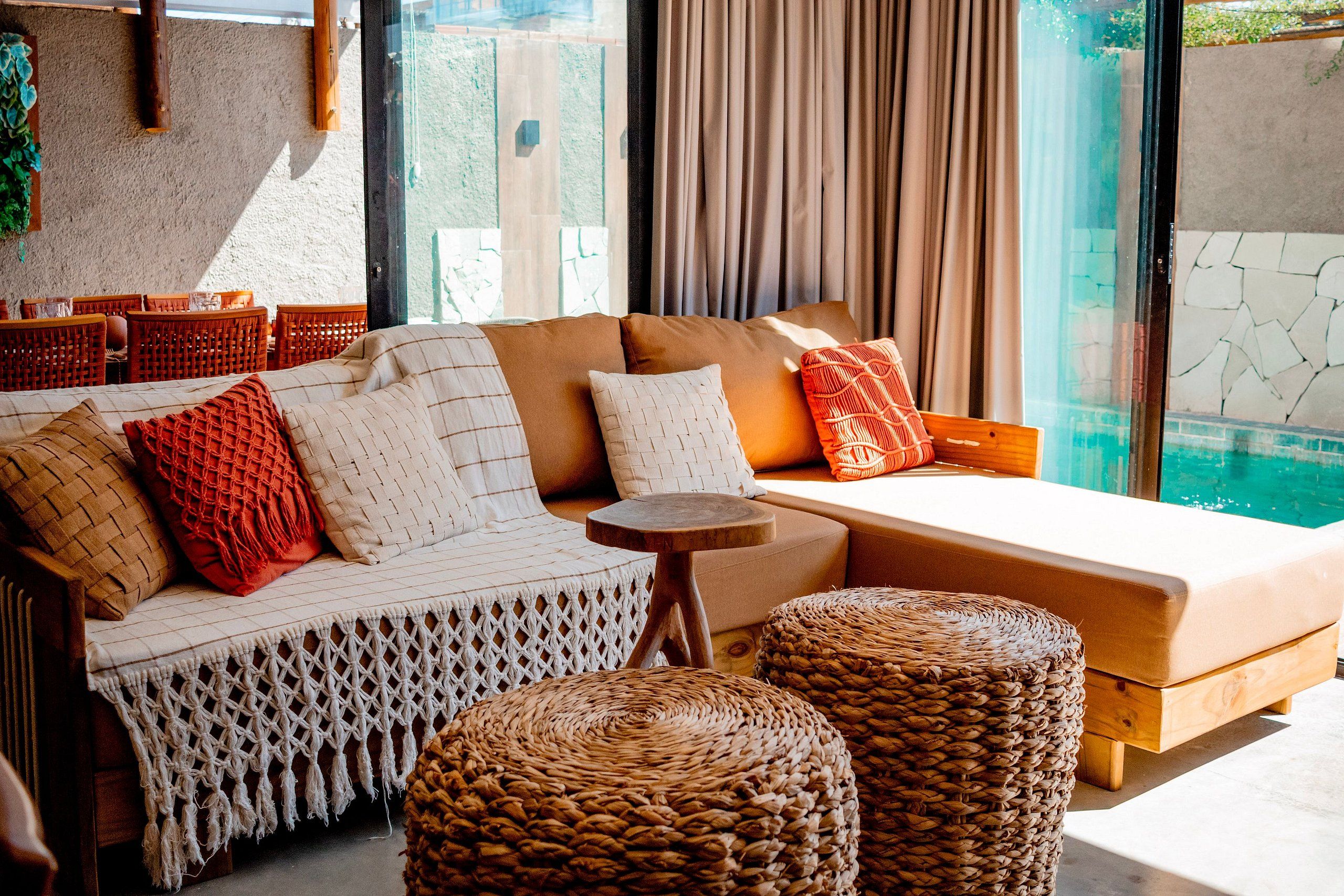 A modern living area with a sofa, ottomans, and a small table.
